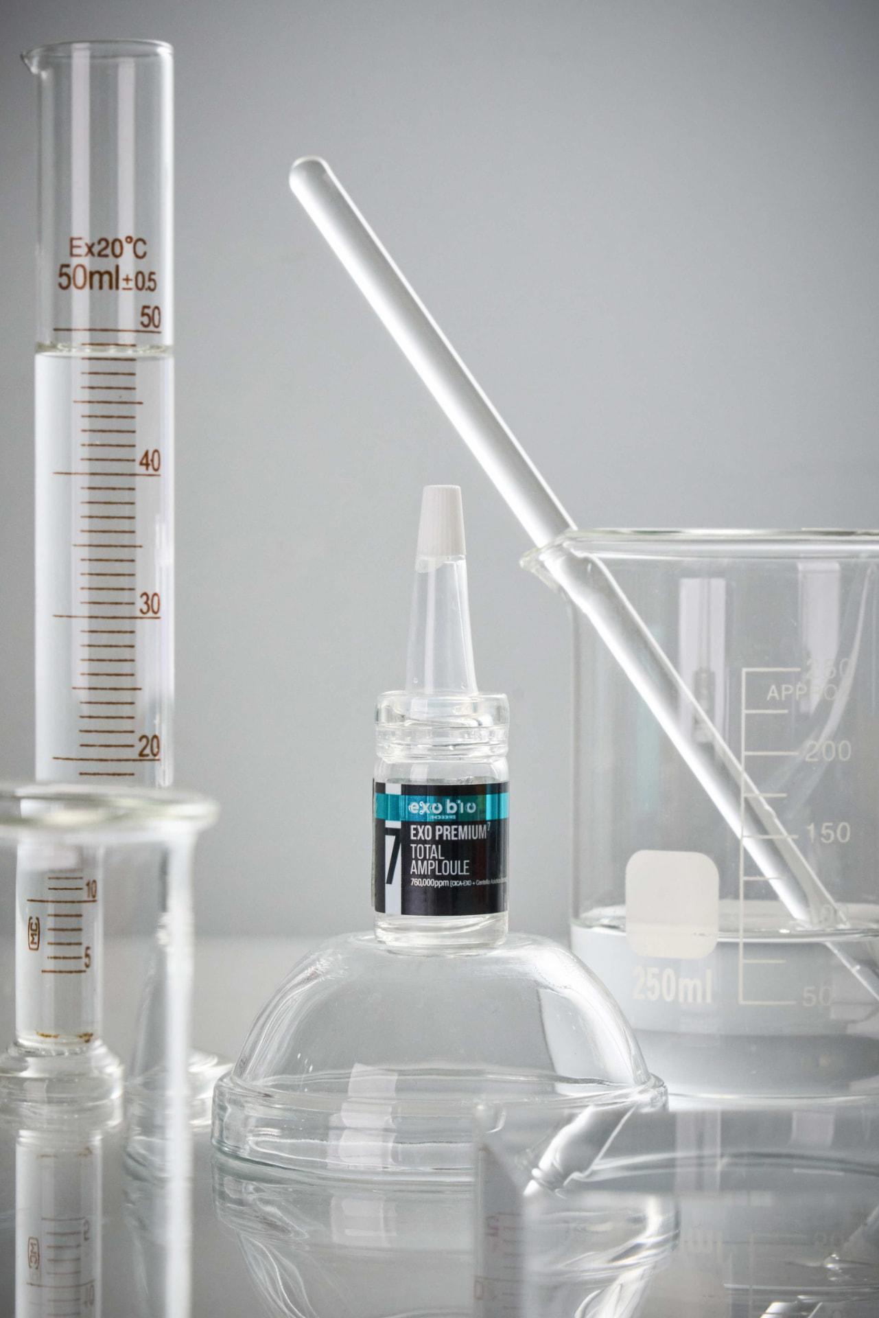 EXO Premium 7 Total Ampoule zwischen Laborglas auf hellem Untergrund